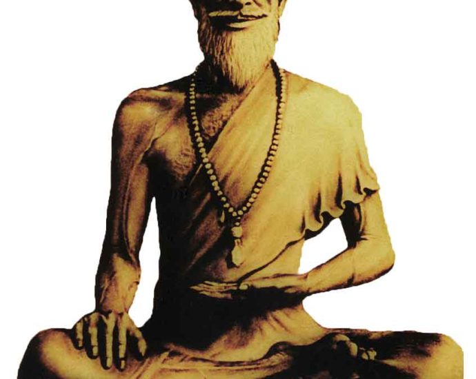 Statue of elderly bearded monk meditating cross-legged